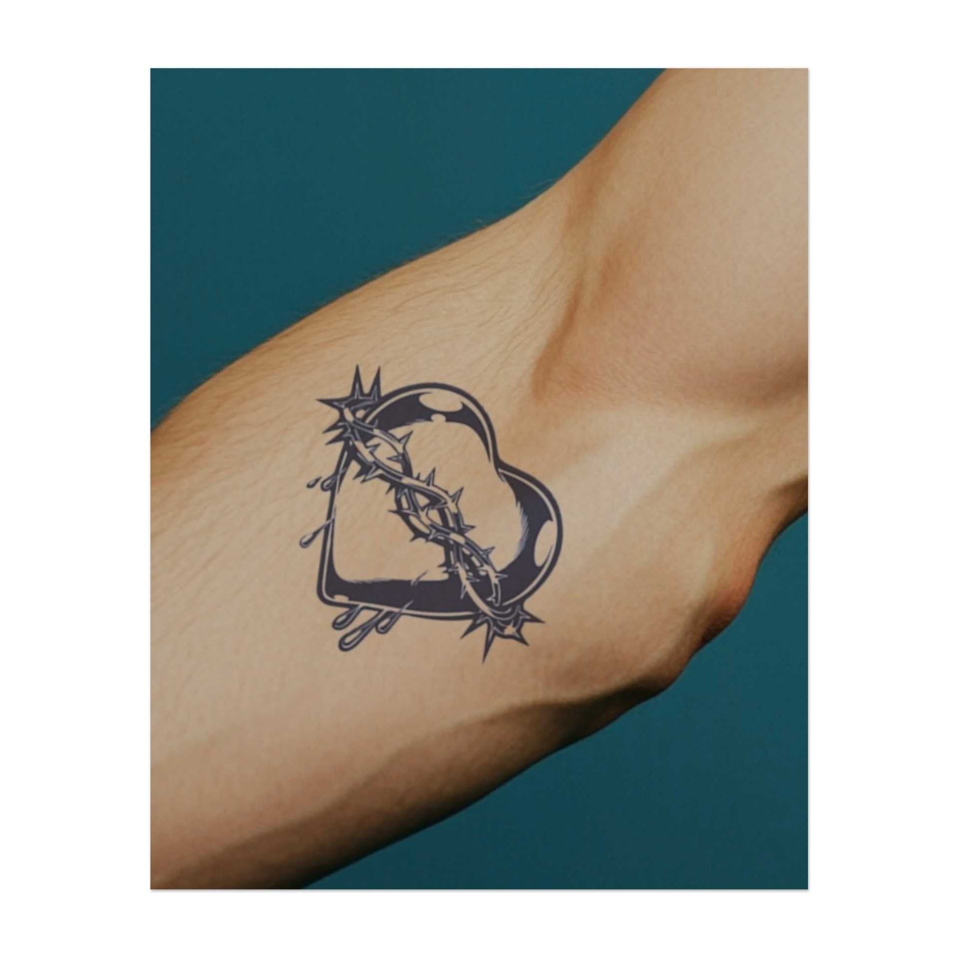 Ein Herz, das in scharfe Dornen gehüllt ist, mit Tränen, die davon tropfen. Dieses Tattoo symbolisiert Liebe, Schmerz und Opfer, was die Komplexität der Emotionen und die Widerstandsfähigkeit repräsentiert, die erforderlich sind, um Herzschmerz und Wachstum zu ertragen.